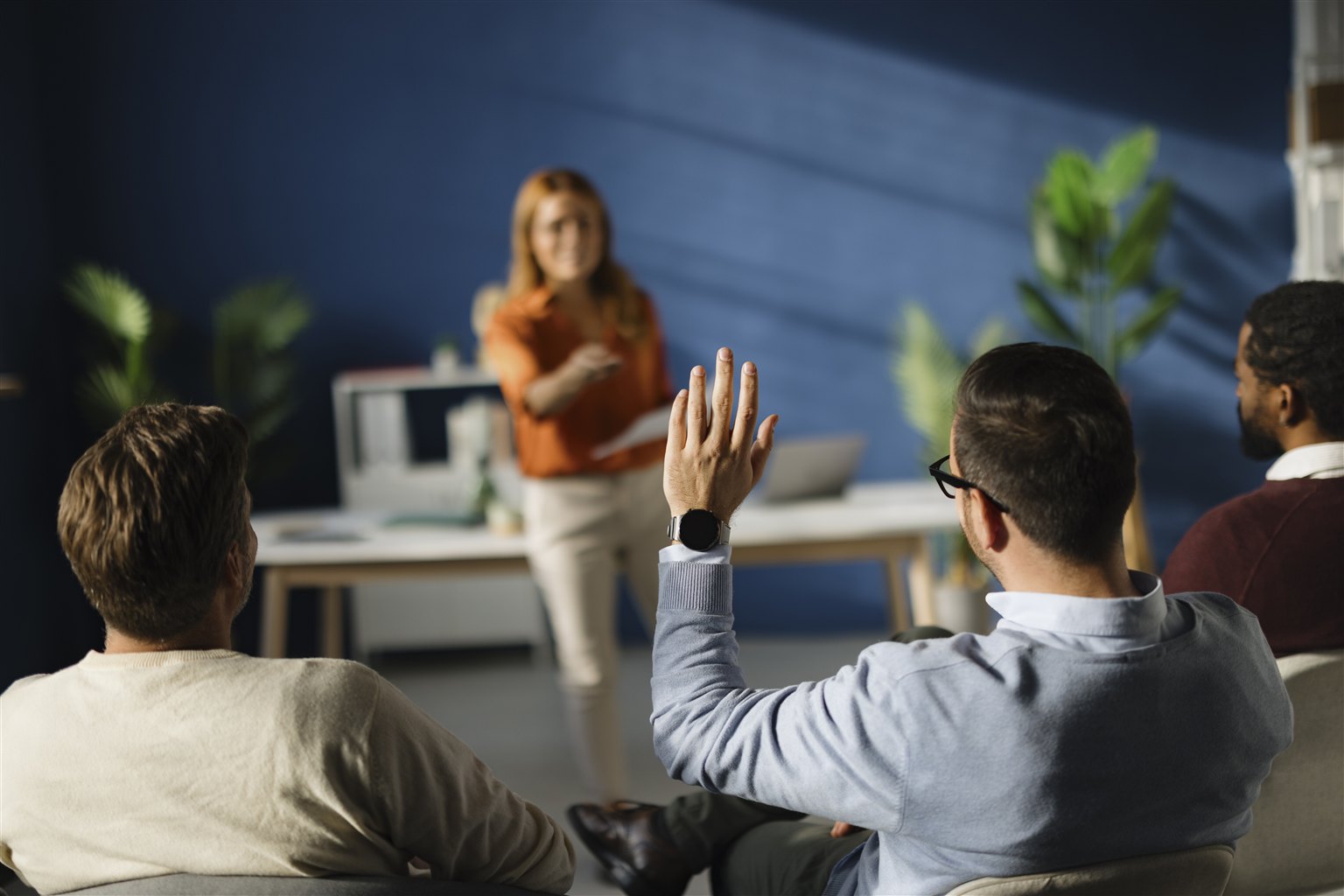 A learner raising a hand during a thoughtful discussion